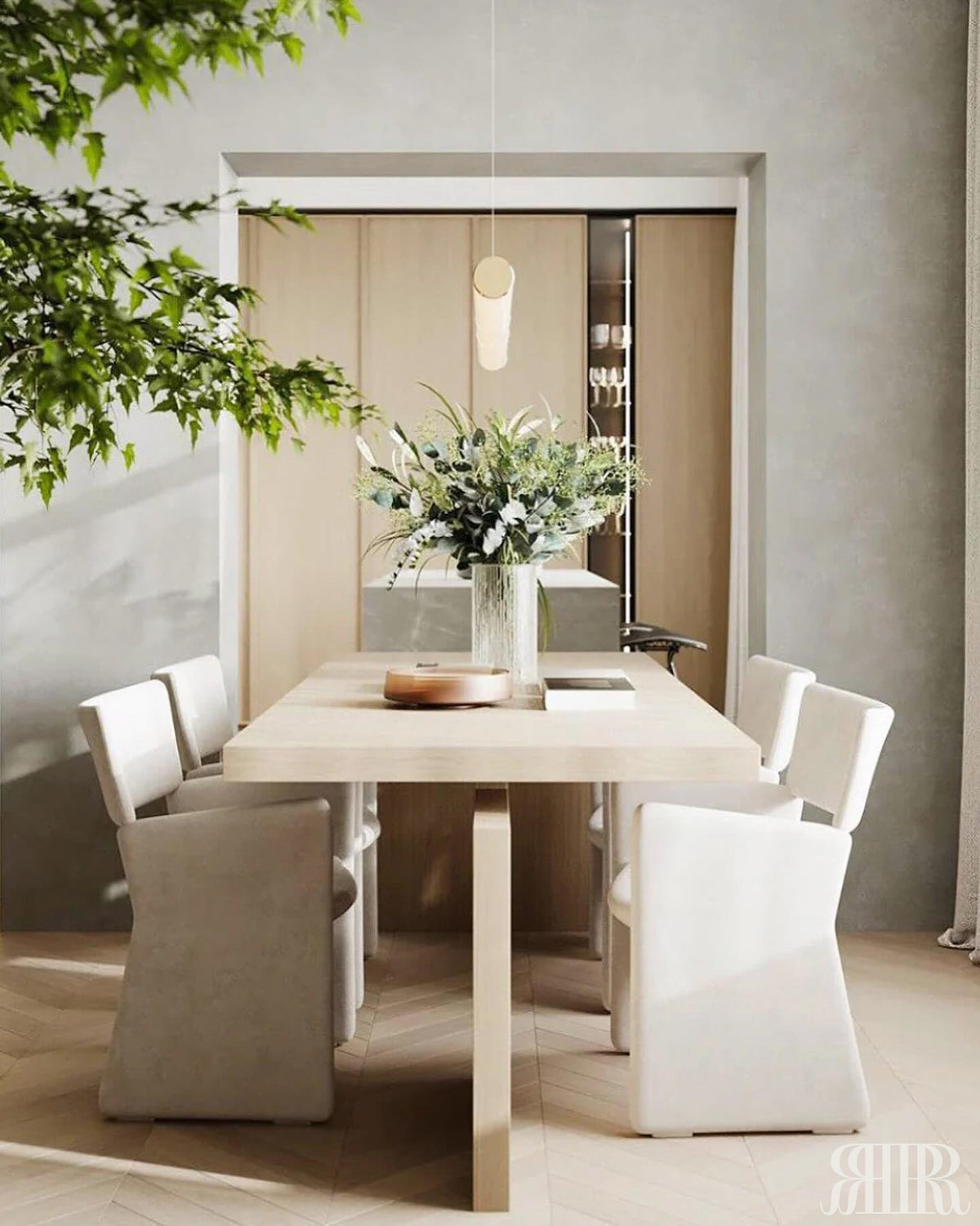 Modern dining room with a white table and chairs, and a vase of flowers.