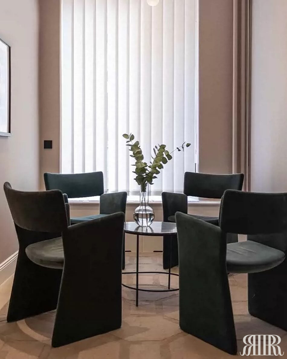 Modern dining room with black chairs and a round table.