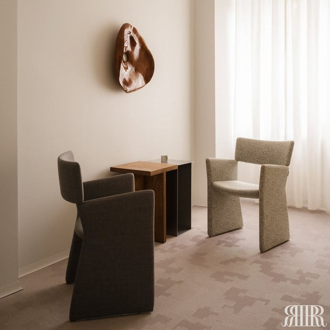 Modern room with gray chairs and a small table against a white wall.