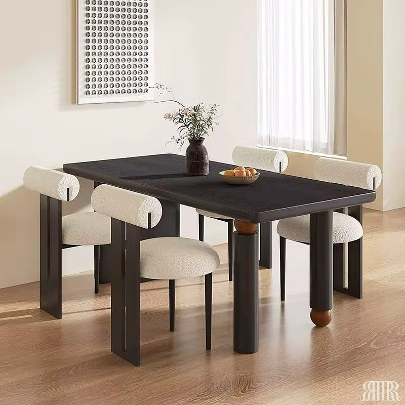 Dining table with four chairs in a room with a window and wall art.