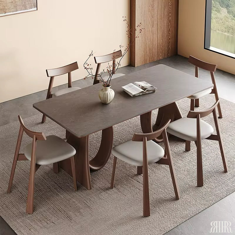 Dining table set with chairs in a room with a window and wall art.