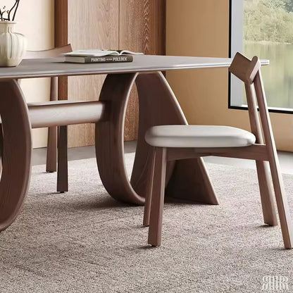 Dining table with modern chairs in a room with a window and decor.