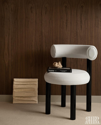 Modern white chair with black legs against a wooden wall