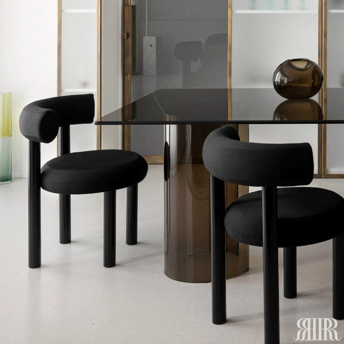 Black chairs and a glass table in a modern interior setting
