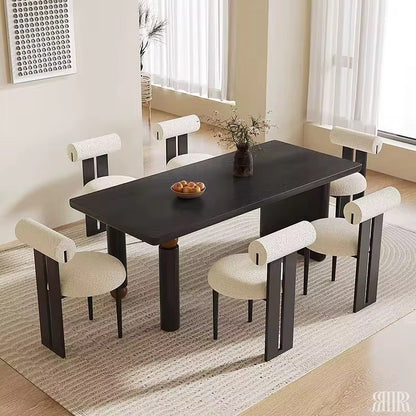 Dining room with a black table and white chairs on a beige rug.