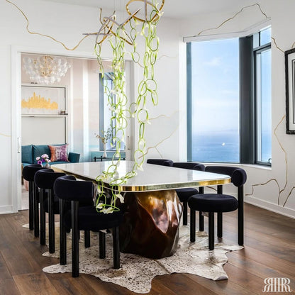 Modern dining room with a reflective dining table and black chairs, large windows, and decorative lighting.