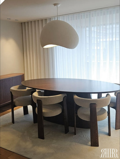 Dining area with a round wooden table and four chairs in a modern interior setting.
